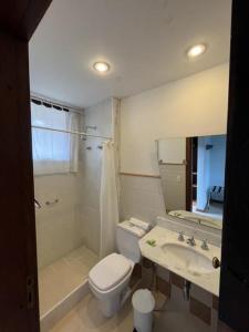 a bathroom with a toilet and a sink and a shower at Hotel São Gotardo in Itamonte