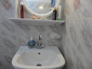 La salle de bains est pourvue d'un lavabo et d'un miroir mural. dans l'établissement Nikolas Villas, à Perivolos