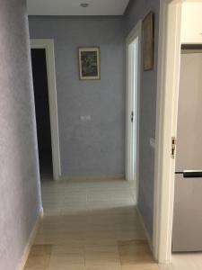 um quarto com um corredor com paredes azuis e piso em azulejo em Appartement à casablanca em Tafza