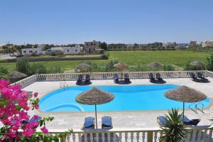 - une piscine avec des chaises longues et des parasols dans l'établissement Nikolas Villas, à Perivolos