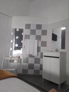 a bathroom with a checkered wall and a sink at Guesthouse Franco in Porto