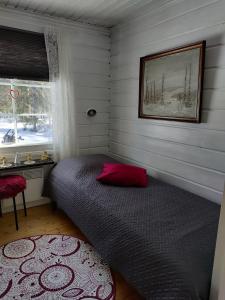 a bedroom with a bed with a red pillow and a window at Villa Bear's in Rovaniemi