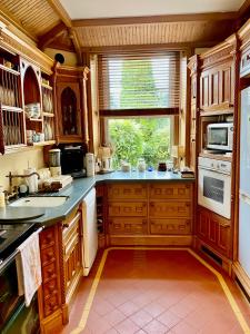 a large kitchen with wooden cabinets and a window at Victorian Villa in New Ross