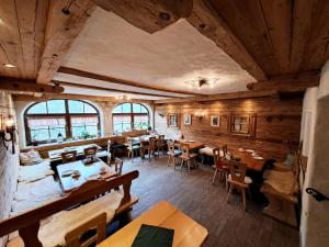 een restaurant met houten vloeren en tafels en stoelen bij Pension Etzerschlössl in Berchtesgaden