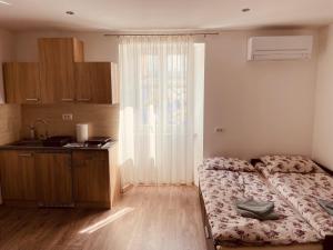 um quarto com uma cama e uma cozinha com uma janela em Blue Sky em Koper