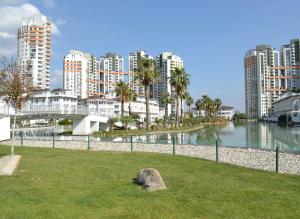 a park next to a body of water with tall buildings at Bursa Dream Apartment in Bursa