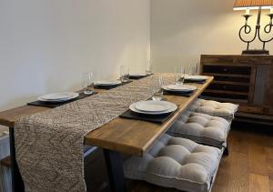 - une table en bois avec des assiettes et des verres à vin dans l'établissement Stunning Beverley Bungalow w Fireplace, private parking, and garden, à Beverley