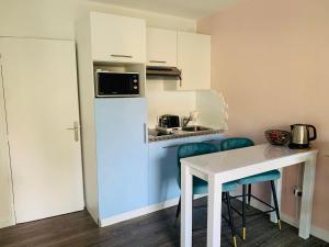 a kitchen with a white refrigerator and a table at Butterfly-Palais des Festival-center-quiet-AC-Wi Fi parking in Cannes