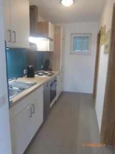 a kitchen with a sink and a stove top oven at Ferienwohnung Lehrberg - Moderne Wohnung mit Wallbox für E-Auto in Lehrberg