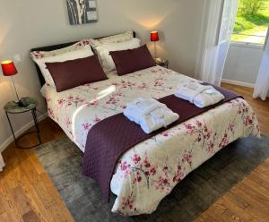 una camera da letto con un letto con asciugamani sopra di Ancien Haras de la Tour a Lamothe-Landerron