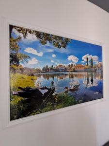 a painting of a lake with ducks in the water at Apartman Amor Trebinje in Trebinje