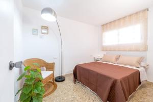 1 dormitorio con cama, lámpara y ventana en 1ªLinea Mar-Piscina-Wifi-PortAventura-Luxury-Chill5, en Salou
