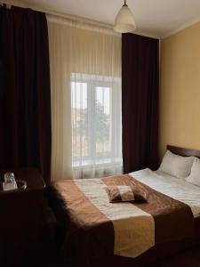 1 dormitorio con 1 cama grande y ventana en Козацькі Забави en Rivne