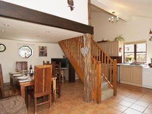 a kitchen and living room with a staircase and a table at St Andrews Barn in Necton