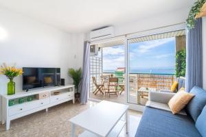 Sala de estar con sofá azul y vistas al océano en 1ªLinea Mar-Piscina-Wifi-PortAventura-Luxury-Chill5, en Salou