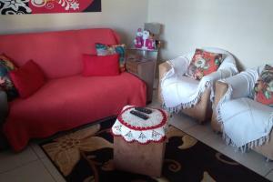 uma sala de estar com um sofá e duas cadeiras em Residencial Praia da Cal - Angelita em Torres