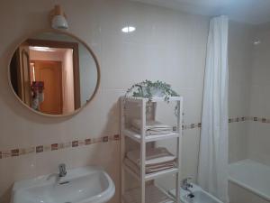 een witte badkamer met een wastafel en een spiegel bij Primera linea de Playa a 10 min Estepona in San Luis de Sabinillas