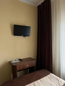 a bedroom with a bed and a television on the wall at Козацькі Забави in Rivne