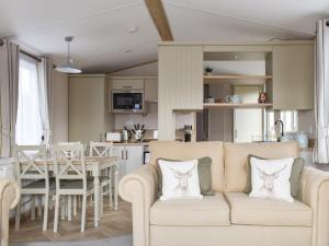 sala de estar y cocina con sofá y mesa en The Willows en Stonham Aspall