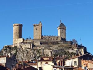 um castelo no topo de uma colina com casas em Charmant Studio Centre de Foix 2ème étage em Foix