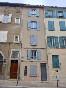 um edifício alto com portas e janelas azuis em Charmant Studio Centre de Foix 2ème étage em Foix