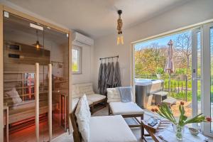 a living room with a large window and a room with a tub at Holiday Home Žrnovnica in Žrnovnica