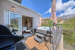 a patio with a swimming pool and an umbrella at Holiday Home Žrnovnica in Žrnovnica