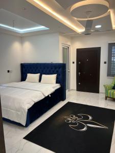 a bedroom with a blue bed with a black rug at HMS SEA VIEW VILLA in Accra