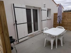 a white table and chairs on a patio at Le Logis de Suzac in Les Mathes