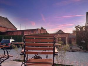 a wooden bench sitting on a sidewalk in a yard at Aparthotel Flughafen Leipzig in Freiroda