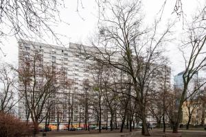 een hoog gebouw met bomen ervoor bij Central Family Apartment in Warschau