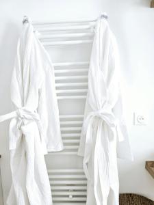 une paire de serviettes blanches suspendues sur un mur dans l'établissement Lakeside Provence - Appartement 4 étoiles face au lac de Monteux, à Monteux