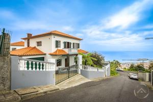 een wit huis met een hek op een straat bij Garden House in Funchal