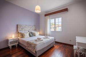 a bedroom with a large bed and a window at Garden House in Funchal