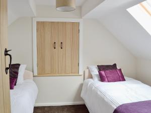 a bedroom with two beds and a cabinet at Roaches View Barn in Wetleyrocks