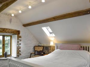 a bedroom with a white bed and a window at Meadow Barn in Shelve