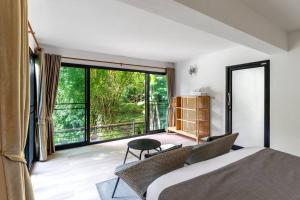 a bedroom with a bed and a large window at Zen MaeKampong Waterfall Villa in Ban Huai Kaeo
