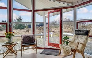 a screened in porch with two chairs and windows at Amazing Home In Ringkbing With Kitchen in Klegod