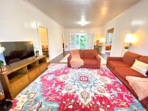 a living room with a couch and a flat screen tv at YOUR HILO HOMEBASE - Lovely 3 Bedroom in Heart of Hilo with AC! in Hilo