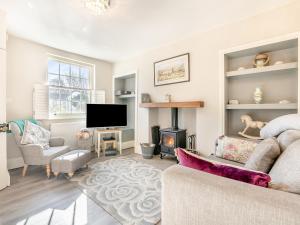 een woonkamer met een bank en een open haard bij Beverley House - Uk43519 in Thornton Dale