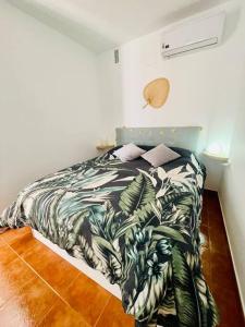 ein Schlafzimmer mit einem Bett mit einer tropischen Tagesdecke in der Unterkunft Casa Lucia Albaicin con terraza in Granada