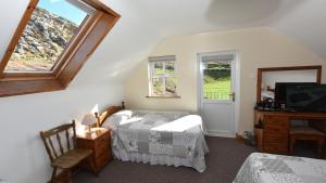 a bedroom with a bed and a tv and windows at Fishermans Village with Sea Views in Downings