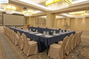 una gran sala de conferencias con una mesa larga y sillas en Ayla Hotel, en Al Ain