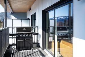 a balcony with a grill and a view of the mountains at The Big Deck by Revelstoke Vacations in Revelstoke