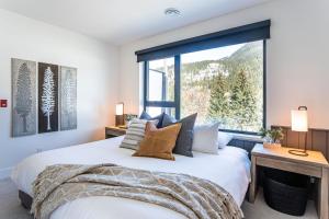 1 dormitorio con cama y ventana grande en The Big Deck by Revelstoke Vacations, en Revelstoke