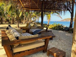 a group of couches sitting on the beach at Casa Las Gatas in Zihuatanejo