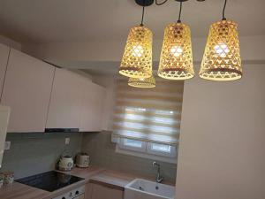 a kitchen with three lights hanging from the ceiling at 'ΟΜΟΡΦΟΣ ΧΩΡΟΣ ΣΤΙΣ ΑΛΥΚΕΣ ΒΟΛΟΥ in Volos