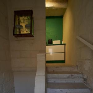 a staircase with a green wall and a window at House of Character in Valletta in Valletta