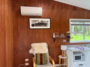 a living room with wood paneling and a white ceiling at Waiora cottage in Otaki