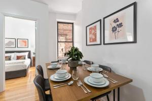 Lovely 3 bedroom apartment in NYC 2 في نيويورك: غرفة طعام مع طاولة خشبية مع كراسي